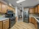 A well-equipped kitchen features wooden cabinets, stainless steel appliances, and a stone backsplash at 6603 Scenic Point Se Dr, Winter Haven, FL 33884