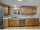 Bright kitchen featuring wooden cabinetry, stainless steel appliances, and a stone-look backsplash at 6603 Scenic Point Se Dr, Winter Haven, FL 33884