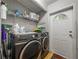 Efficient laundry room with modern washer and dryer, shelving, and exterior access door at 6603 Scenic Point Se Dr, Winter Haven, FL 33884