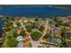 Aerial view of a lakeside neighborhood with a home surrounded by mature trees and greenery at 6754 Winterset Gardens Rd, Winter Haven, FL 33884