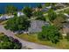 Aerial view of property near lake with mature trees, screened pool, and lush landscaping at 6754 Winterset Gardens Rd, Winter Haven, FL 33884
