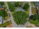 Aerial view of property featuring mature trees, green lawns, and screened pool at 6754 Winterset Gardens Rd, Winter Haven, FL 33884