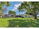 A spacious backyard with green grass surrounding the home, along with screened-in porch at 6754 Winterset Gardens Rd, Winter Haven, FL 33884
