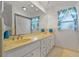 Bathroom with a double sink vanity, bright lighting and vibrant, nautical themed decorations at 6754 Winterset Gardens Rd, Winter Haven, FL 33884