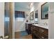 Well-lit bathroom offers double sinks, wood cabinets, and an ornate mirror at 6754 Winterset Gardens Rd, Winter Haven, FL 33884