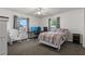 Bedroom with two windows, computer setup, and a cozy chair, perfect for relaxing or working at 6754 Winterset Gardens Rd, Winter Haven, FL 33884
