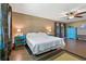 Primary bedroom features wood floors, a ceiling fan, and blue bedside tables at 6754 Winterset Gardens Rd, Winter Haven, FL 33884