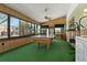 Recreation room with a pool table, bright green carpet, and panoramic windows at 6754 Winterset Gardens Rd, Winter Haven, FL 33884