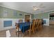 Open dining room with wood floors, a blue tablecloth, and a ceiling fan at 6754 Winterset Gardens Rd, Winter Haven, FL 33884