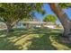 Charming single-story home with a lush front yard and mature trees providing shade on a sunny day at 6754 Winterset Gardens Rd, Winter Haven, FL 33884