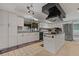 Modern kitchen with white cabinets, stainless steel appliances, island and tile flooring at 6754 Winterset Gardens Rd, Winter Haven, FL 33884
