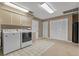 Well-lit laundry room with tile flooring, washer, dryer, cabinets and ample storage at 6754 Winterset Gardens Rd, Winter Haven, FL 33884