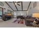 Comfortable living room featuring vaulted ceilings, wood beams, and a cozy seating arrangement at 6754 Winterset Gardens Rd, Winter Haven, FL 33884