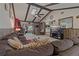 Inviting living room with vaulted ceilings, stylish beams, and a view of the kitchen and fireplace at 6754 Winterset Gardens Rd, Winter Haven, FL 33884