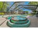 Outdoor pool area featuring a hot tub and a screened enclosure, perfect for recreation and relaxation at 6754 Winterset Gardens Rd, Winter Haven, FL 33884