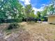 Expansive backyard, featuring lush trees, offering a private and serene outdoor space at 799 W Lake Otis Dr, Winter Haven, FL 33880