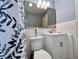 Bright bathroom with a leafy shower curtain, vanity, and mirror at 799 W Lake Otis Dr, Winter Haven, FL 33880