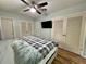 Bright bedroom with a ceiling fan, warm wood flooring, a mounted television, and closet space at 799 W Lake Otis Dr, Winter Haven, FL 33880