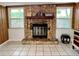 Close up of a stone fireplace, set between two windows, decorated with books and trinkets at 799 W Lake Otis Dr, Winter Haven, FL 33880
