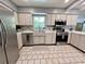 Charming kitchen with stainless steel appliances, decorative backsplash, and light-colored cabinets at 799 W Lake Otis Dr, Winter Haven, FL 33880