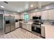 Well-lit kitchen boasts stainless steel appliances, tile backsplash, and plenty of countertop space at 799 W Lake Otis Dr, Winter Haven, FL 33880