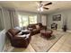 Inviting living room with plush leather seating, ceiling fan, and a large window overlooking the outdoors at 799 W Lake Otis Dr, Winter Haven, FL 33880
