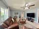 Relaxing living room with comfortable brown sofa, ceiling fan, and view to backyard at 799 W Lake Otis Dr, Winter Haven, FL 33880