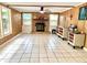 Spacious living room with stone fireplace, wood paneled walls, and tile flooring at 799 W Lake Otis Dr, Winter Haven, FL 33880
