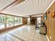 Bright, airy living room with a stone fireplace, ceiling fan, and large windows at 799 W Lake Otis Dr, Winter Haven, FL 33880