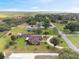 Aerial view of a home with a horseshoe driveway and mature landscaping, surrounded by trees and a distant lake at 8947 Oakwood Dr, Lake Wales, FL 33898