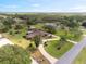 Aerial shot of home with a circular driveway, lush lawn, trees, and a private rural setting at 8947 Oakwood Dr, Lake Wales, FL 33898