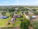 Aerial shot of the home with lush greenery, circular driveway, mature trees, and serene neighborhood at 8947 Oakwood Dr, Lake Wales, FL 33898
