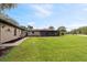 Expansive backyard featuring lush lawn, landscaping, and a screened-in lanai, perfect for outdoor living at 8947 Oakwood Dr, Lake Wales, FL 33898