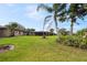 Large backyard with lush lawn, mature landscaping, and screened lanai ideal for outdoor entertaining and relaxation at 8947 Oakwood Dr, Lake Wales, FL 33898