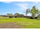 Vast backyard showcasing mature landscaping, a detached garage, and ample space for outdoor activities at 8947 Oakwood Dr, Lake Wales, FL 33898