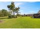 Expansive backyard featuring lush green lawn, mature trees, and well-maintained landscaping at 8947 Oakwood Dr, Lake Wales, FL 33898