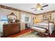 Cozy bedroom featuring a ceiling fan, dresser, and four poster bed at 8947 Oakwood Dr, Lake Wales, FL 33898