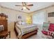 Bedroom with ceiling fan, quilted bedspread, and lace-curtained window at 8947 Oakwood Dr, Lake Wales, FL 33898