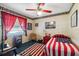 Themed bedroom with a ceiling fan, American flag quilt, and dark blue carpet at 8947 Oakwood Dr, Lake Wales, FL 33898
