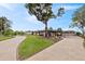 Spacious driveway leads to home with a well-manicured lawn and carport at 8947 Oakwood Dr, Lake Wales, FL 33898