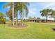 Ranch-style home with lush green lawn, mature landscaping, and palm trees in the front yard at 8947 Oakwood Dr, Lake Wales, FL 33898