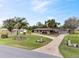 Well-maintained ranch-style home with a lush green lawn, mature trees, and landscaping at 8947 Oakwood Dr, Lake Wales, FL 33898