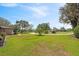 Lush front yard with circular driveway, mature trees, and manicured landscaping at 8947 Oakwood Dr, Lake Wales, FL 33898