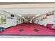 Large garage space with custom red carpet and ample room for work or projects at 8947 Oakwood Dr, Lake Wales, FL 33898