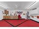 Spacious garage with red carpet, ample lighting, ceiling fan and storage cabinets at 8947 Oakwood Dr, Lake Wales, FL 33898