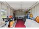 Spacious garage interior with tool bench, storage, and red flooring providing ample space for projects and parking at 8947 Oakwood Dr, Lake Wales, FL 33898