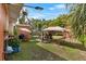 The sunny back yard featuring a patio set, tent, privacy fence, and grassy lawn at 903 S Lakeview Ave, Bartow, FL 33830