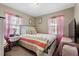 Bedroom with floral bedding, a ceiling light, and bright pink curtains at 903 S Lakeview Ave, Bartow, FL 33830