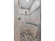 Modern shower featuring tile walls with blue accents and a decorative pebble floor at 903 S Lakeview Ave, Bartow, FL 33830