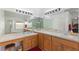 Bathroom featuring dual sinks, wood cabinets, and large mirrors at 916 Balmoral Dr, Davenport, FL 33896